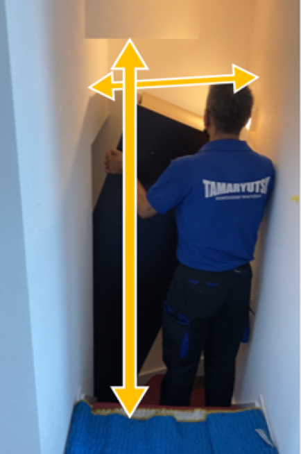 戸建ての階段で家具を搬入している様子